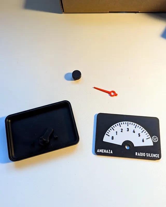 Las piezas del dial sin montar: la caja con el rotor, el mando, la aguja y el frente con la escala